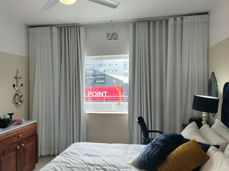 Grey curtains with white sheers fitted in a Cape Town bedroom