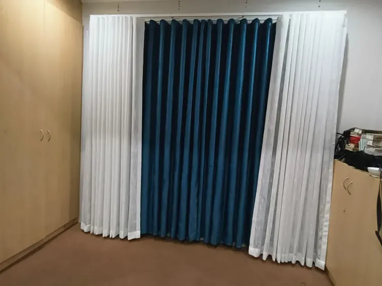 Teal curtains flanked by white sheers fitted in a Cape Town room