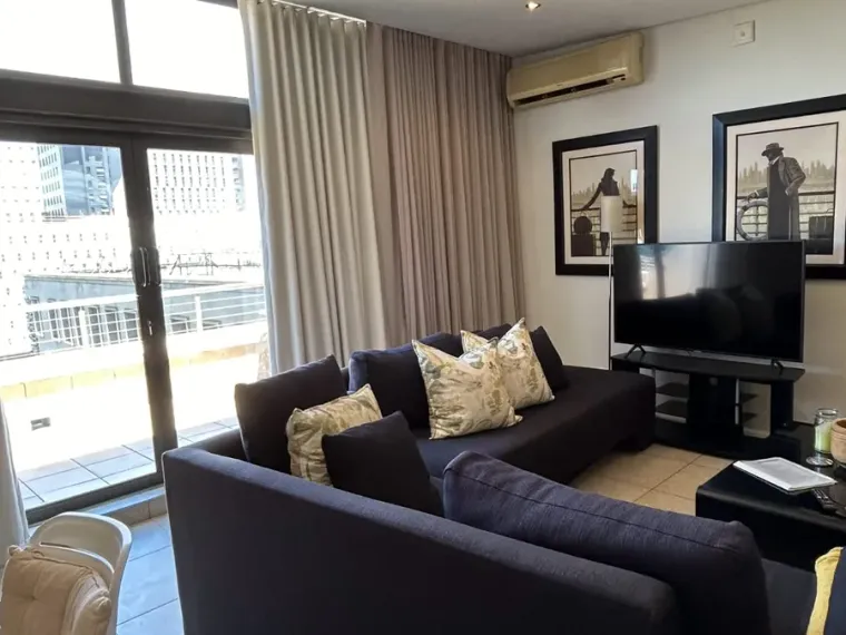 Taupe wave curtains at a sliding door in a Cape Town apartment lounge