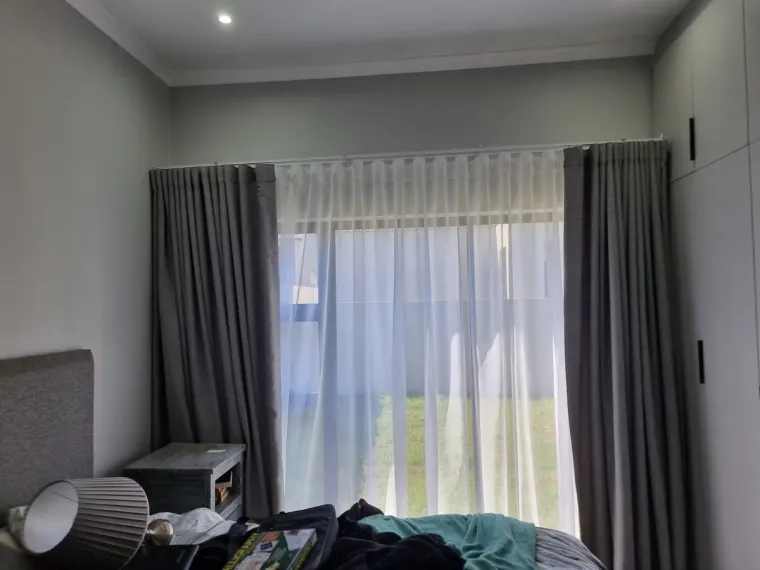 Charcoal curtains layered over white sheers in a Cape Town bedroom