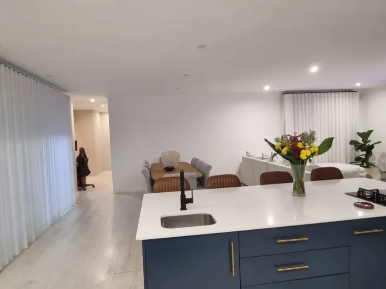 White sheer curtains in an open-plan Cape Town kitchen and lounge