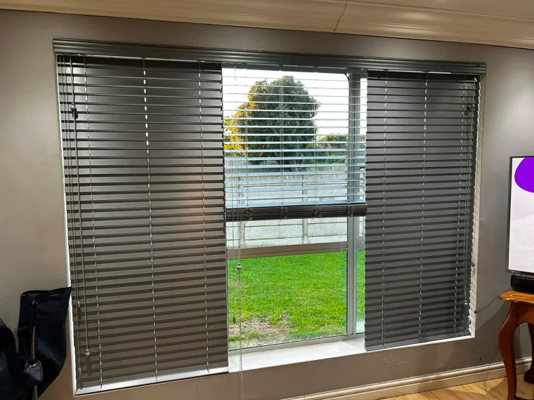 Grey venetian blinds on a large lounge window in Cape Town