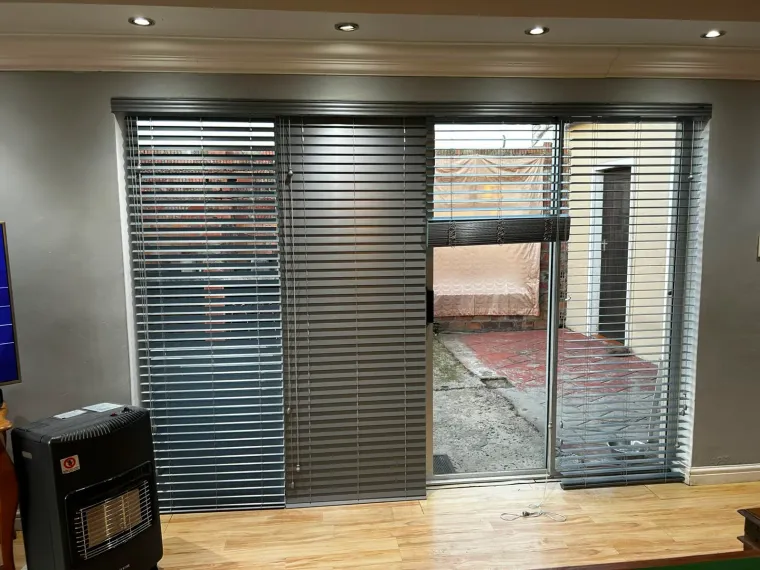 Grey venetian blinds fitted on a sliding door in a Cape Town lounge