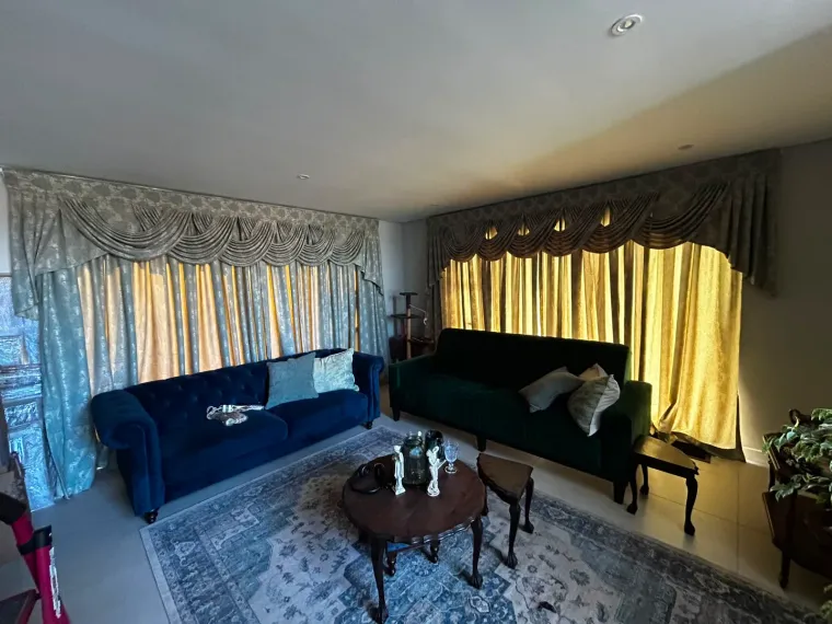 Grey and gold pelmet curtains with swag valances in a formal Cape Town lounge